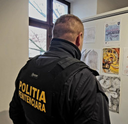 A policeman looking at artwork created by prison inmates about domestic violence